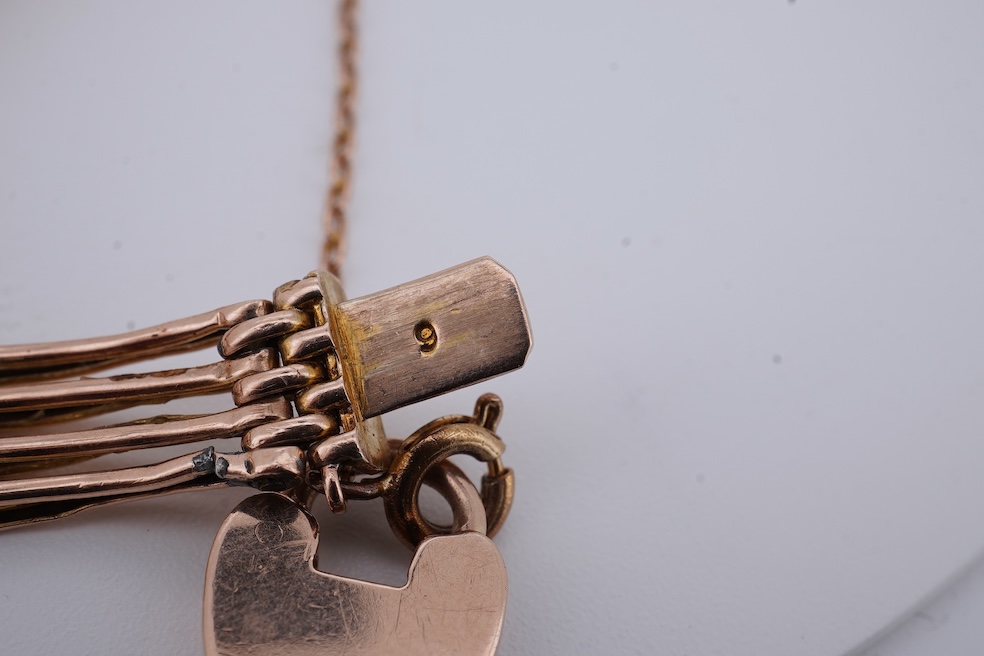 An early 20th century yellow metal gate link bracelet, with heart shaped padlock clasp on safety chain, stamped '9', approx. 18cm, 9.2 grams. Condition - poor